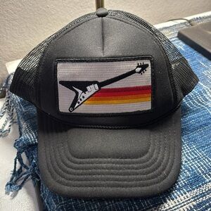 Aviator Nation X Gibson U.S.A. Black Trucker Hat with flying-V and Rainbow Logo.